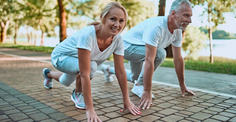 A middle aged couple enjoy the benefits of being able to exercise pain free outdoors in the sunshine. 