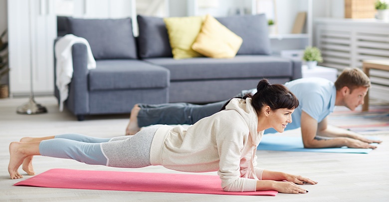 couple doing a plank at home 